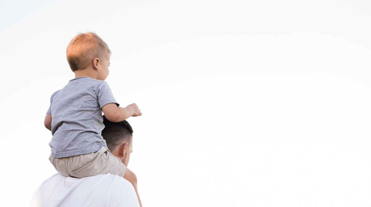 Father carrying his son on his shoulders, symbolizing that paternity matters.