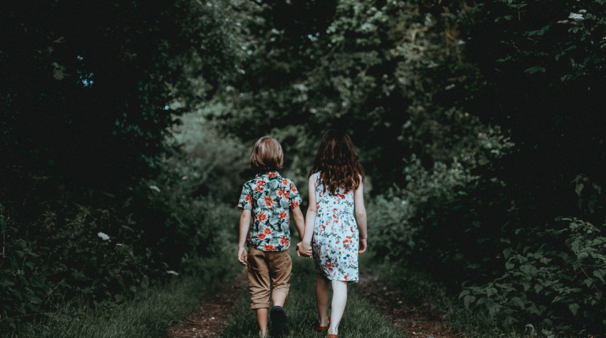 Two children walk down a dark path in the woods, a metaphor for parents that possibly haven't paid for Florida child support.